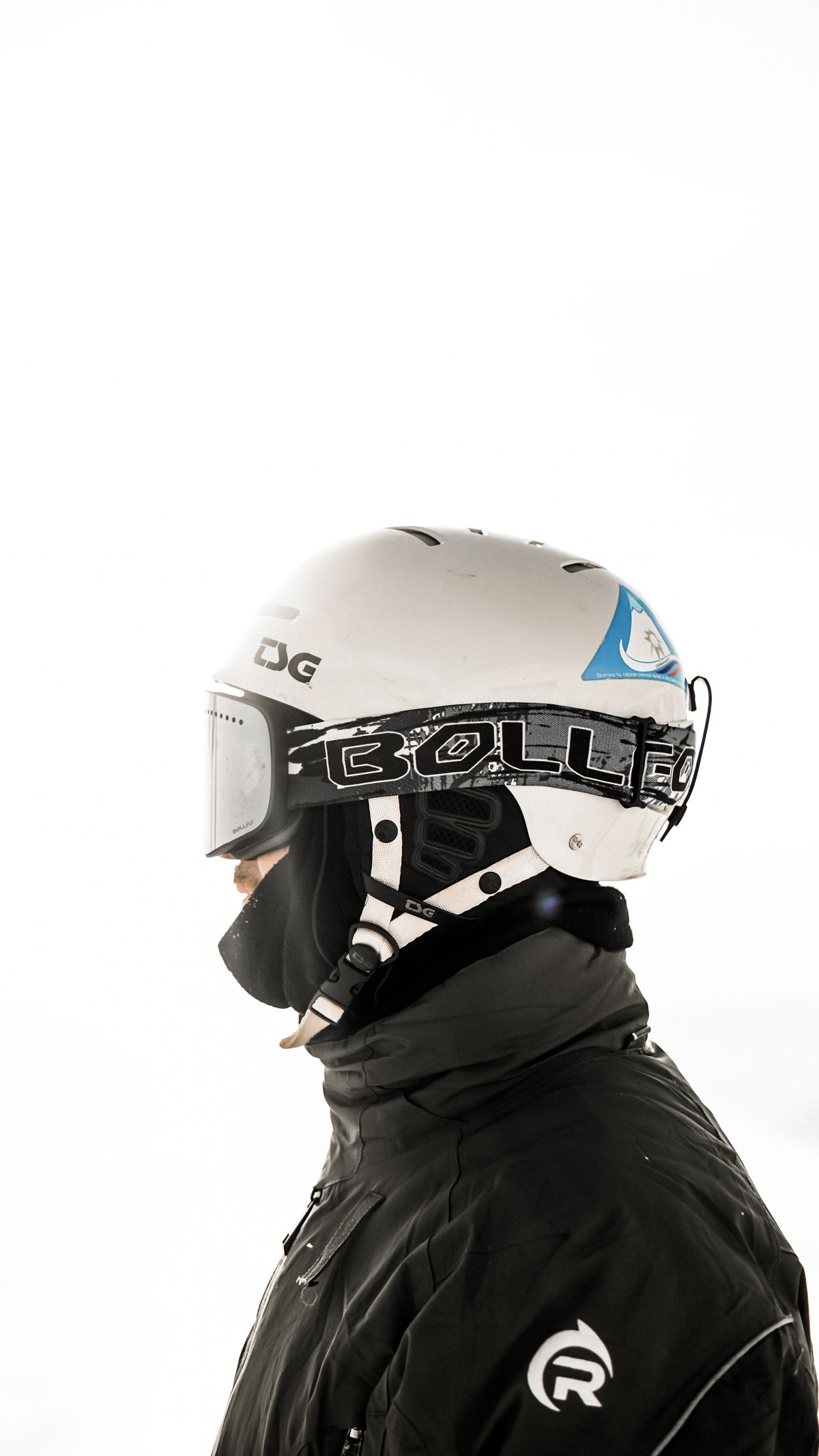 Close-up side view of a skier wearing a helmet and goggles, ready for winter action.